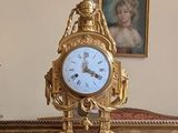 une horloge en or posée sur une table en marbre