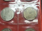 an assortment of silver coins in a red case