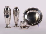 trois vases en argent posés l'un à côté de l'autre sur une table