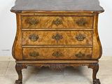 une commode ancienne avec un plateau en marbre, posée sur un sol carrelé