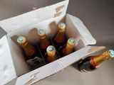 six bottles of wine in a cardboard box on a table