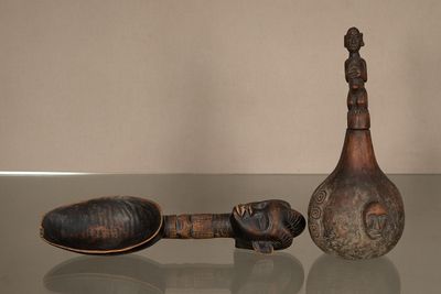 des bouteilles et des cuillères posées sur une table en verre, avec un mur en arrière-plan