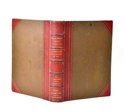 un vieux livre à la couverture rouge posé sur une table blanche