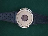a close up of a wrist watch on a green surface