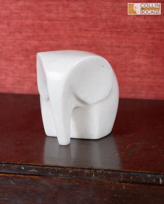 une figurine d'éléphant blanc posée sur une table en bois