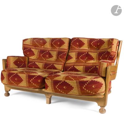 a red and yellow patterned couch with wooden legs