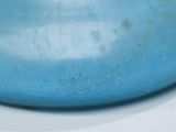 a blue vase with a bird on it sitting on a table