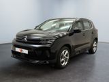 Une Citroën noire est garée dans une grande pièce