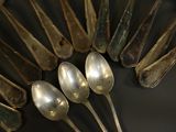 several silver spoons are arranged in a circle on a black surface