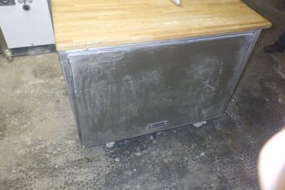 un micro-ondes argenté posé sur un plan de travail en bois