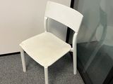 a white chair sitting in front of a glass door