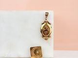 un fermoir en or orné d'un petit diamant et d'un petit pendentif carré