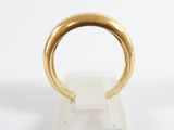 a close up of a gold ring on a clear stand