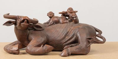 une statue représentant une vache sur laquelle est assis un groupe de personnes