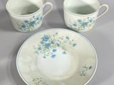 two cups and a saucer sitting on a table