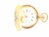 a gold pocket watch on a white surface with a white background