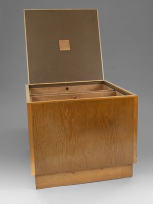 une boîte en bois avec un couvercle ouvert sur fond gris