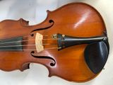 an old violin sitting on top of a white table next to a keyboard