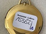 a close up of a gold pocket watch with a label on it