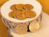 a pile of coins sitting on top of a tree stump