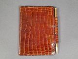 crocodile skin wallet with a gold bar on the front