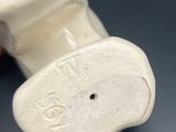 a white vase that has a small elephant on it
