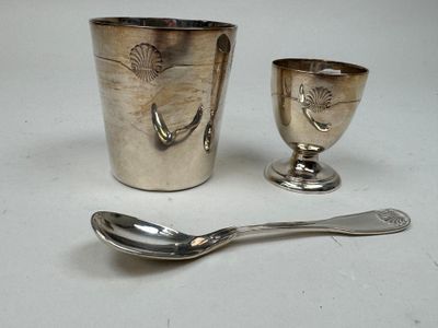 une tasse et une cuillère en argent posées l'une à côté de l'autre sur une table