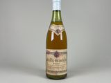 une bouteille de vin posée sur une table blanche