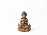 une statue en or représentant un Bouddha assis sur un socle blanc