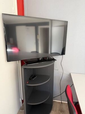 a flat screen tv sitting on a stand in a room