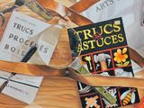 a painting of a pair of scissors and a book on a table