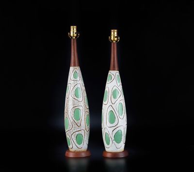 deux vases verts et blancs posés sur une surface noire