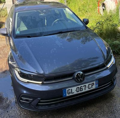 La voiture est garée sur le bord de la route, à côté d'une pompe à essence.