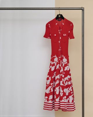La robe est rouge et blanche, avec des fleurs blanches dessus.