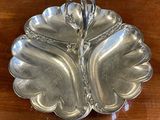 a silver plate on a wooden table with a spoon in it