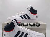 une paire de baskets blanches et bleues posée sur une boîte