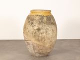 a vase that is sitting on the floor in front of a white wall