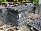 a pile of black plastic plates sitting on a pallet
