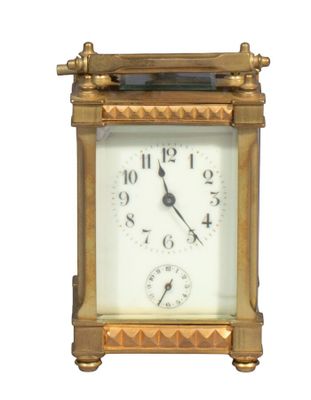 une horloge dorée avec un cadran blanc sur fond blanc