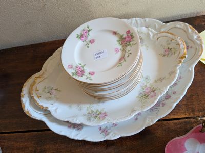 une pile d'assiettes posée sur une table en bois, à côté d'un bol rose