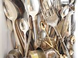 une boîte blanche remplie de cuillères en argent et de cuillères