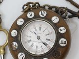 a clock and a key on a chain on a table