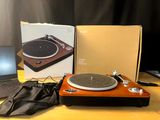 un tourne-disque posé sur une table, à côté d'un ordinateur portable