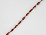a red beaded bracelet with silver beads on a white background