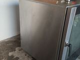 an image of a small stainless steel refrigerator in a garage