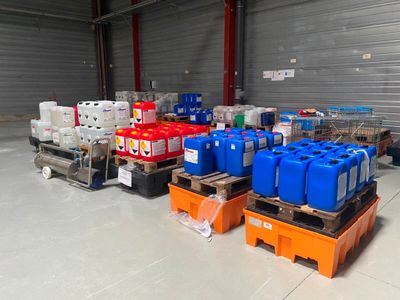 de nombreux conteneurs d'eau posés sur des palettes dans un entrepôt