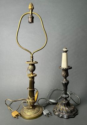 pair of antique brass candlesticks and a candle holder on a grey background