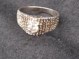 silver ring with a textured surface on a black cloth