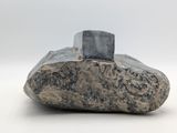 a rock with a stone on top of it on a white surface