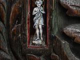 a statue of a man holding a staff in a carved wood frame